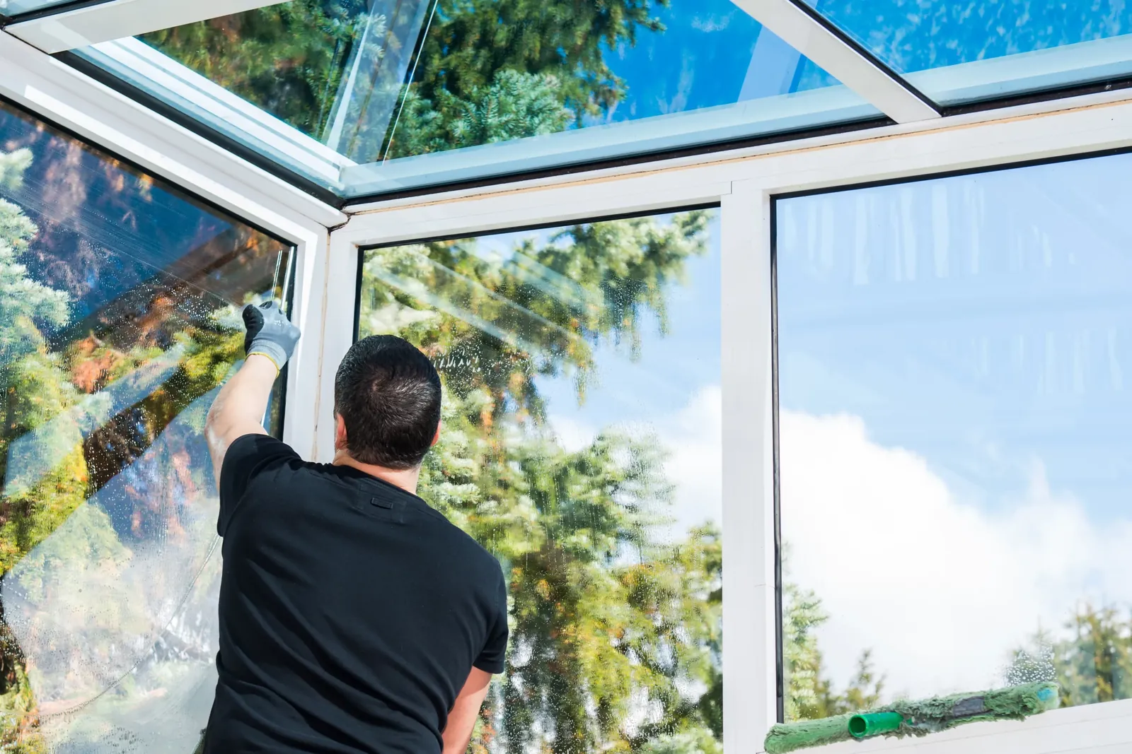 Fönsterputsning i en ljus glasveranda